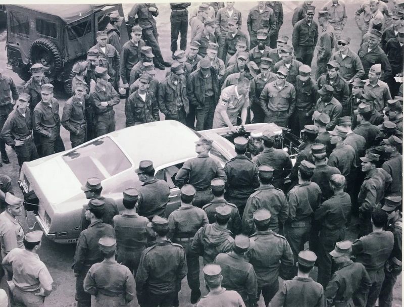 Group of soldiers gathered around a car.