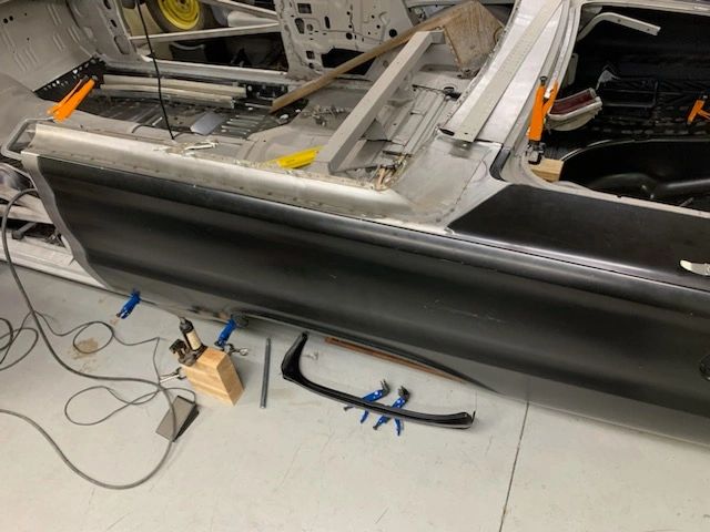 Car restoration project with tools and clamps.