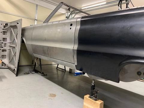 Car body restoration in progress in garage.