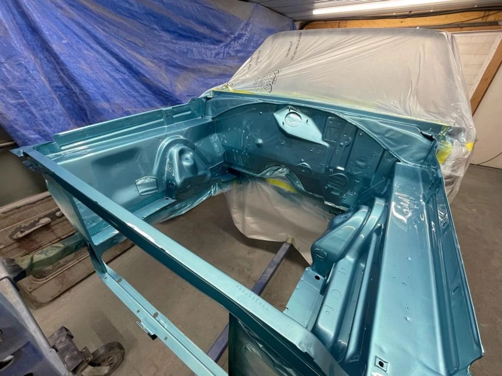 Car engine bay painted metallic blue.