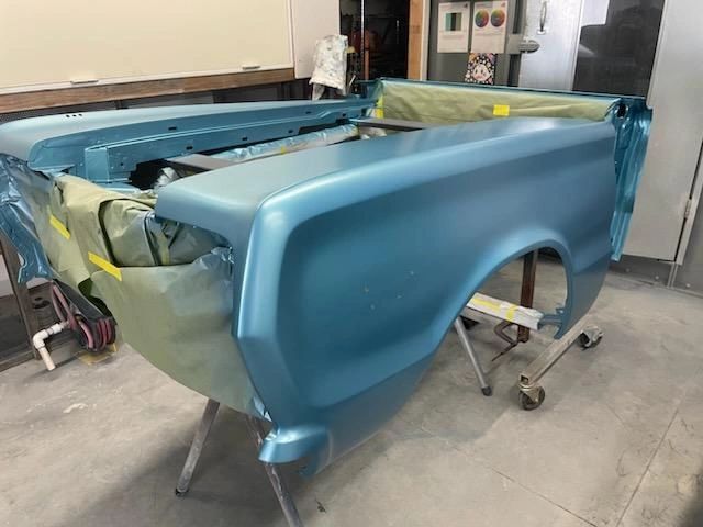 Blue car body in a workshop.