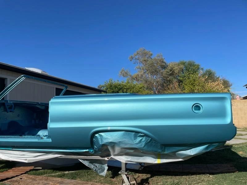 Blue car body under clear blue sky.