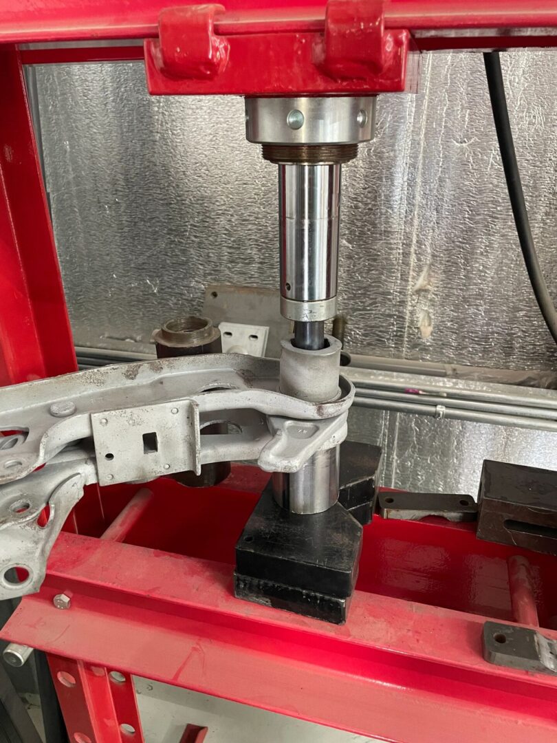 Hydraulic press working on metal component.