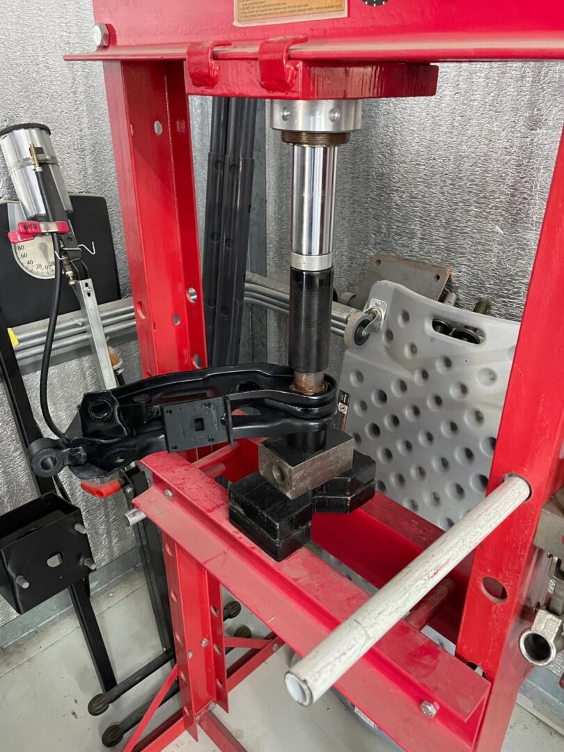 Hydraulic press with car suspension part.