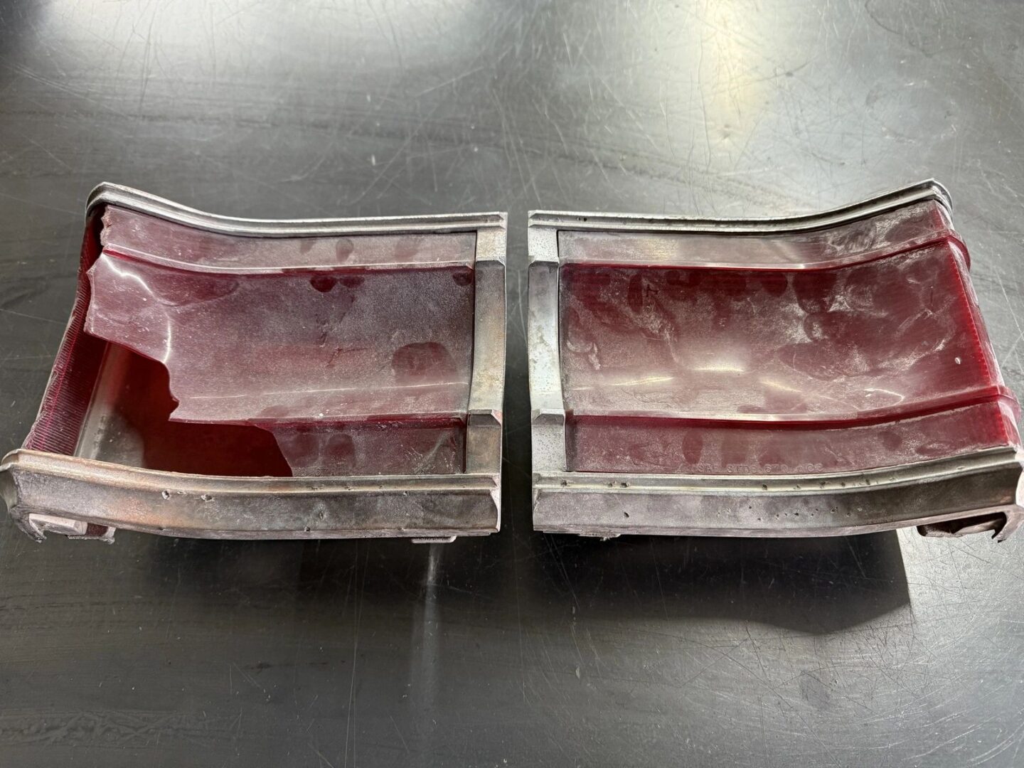 Broken red tail light on black surface.