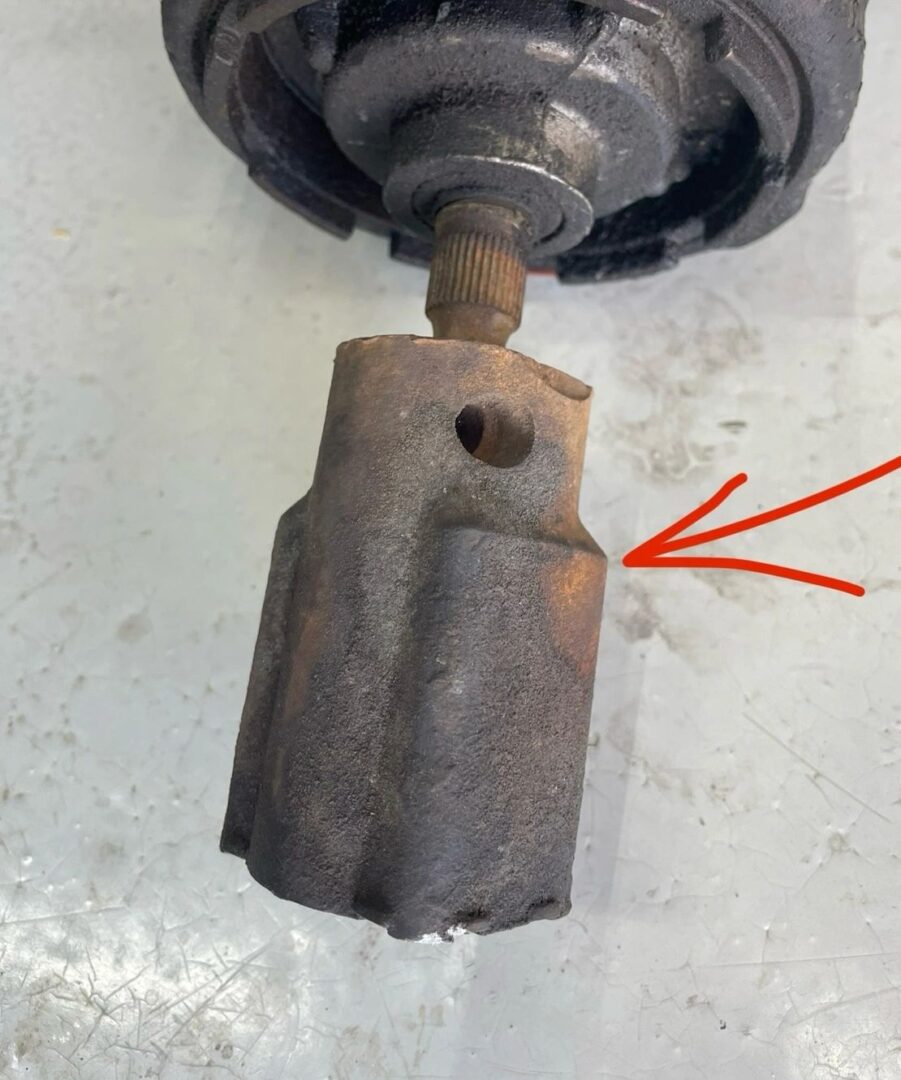 Rusty mechanical part with red arrow pointing.