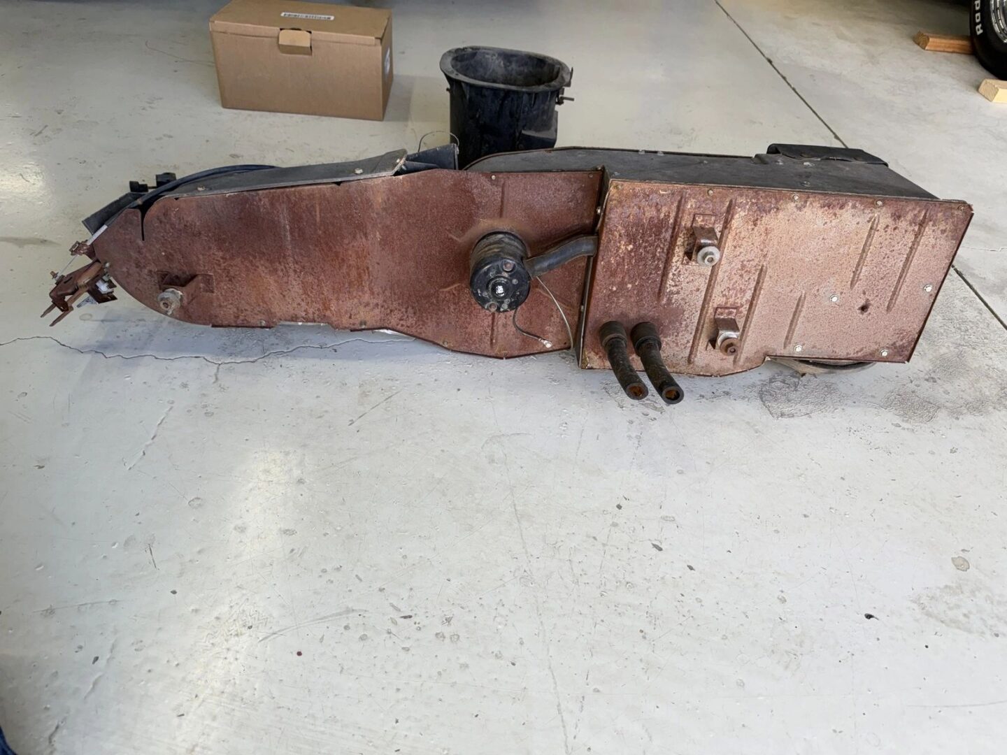 Rusty metal part on garage floor.