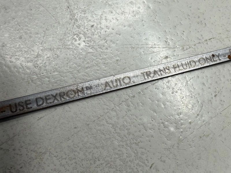Metal rod with engraved text on surface.