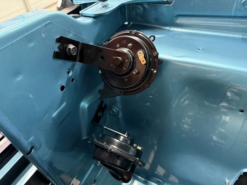 Car engine bay with mounted components.