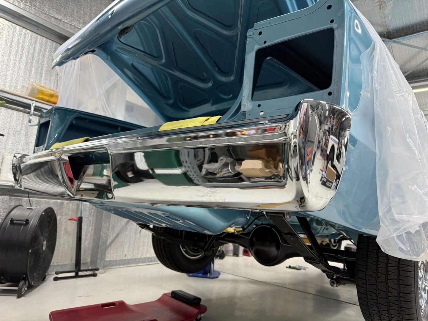 Classic car bumper in a garage workshop.