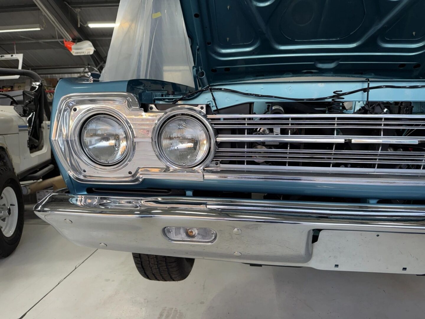 Classic blue car with hood open.