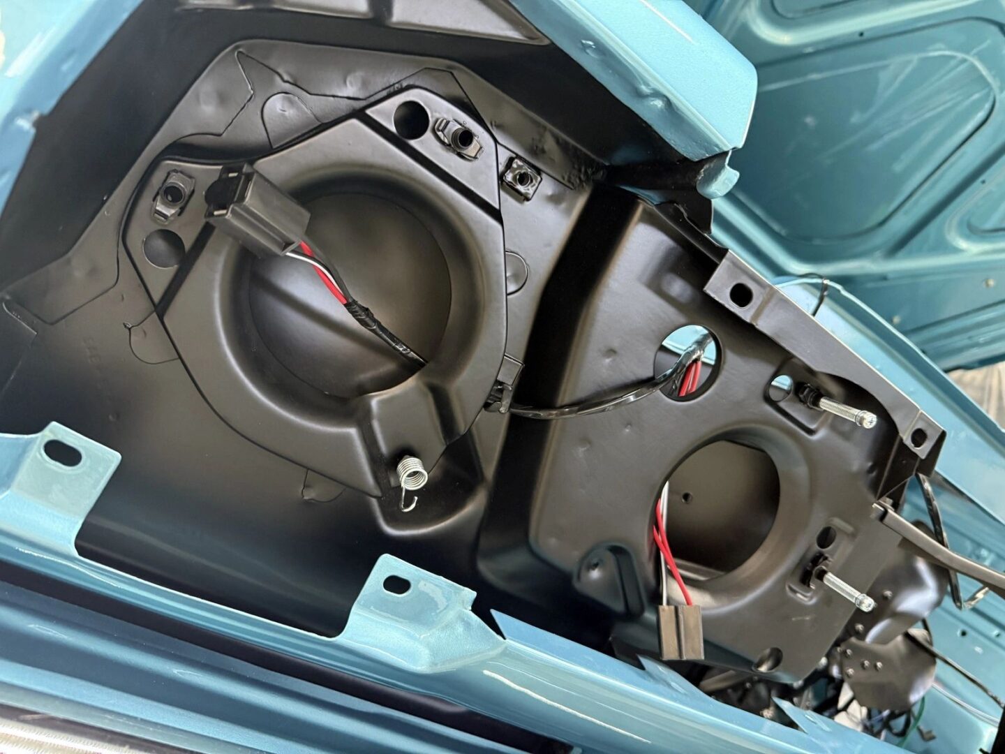 Car trunk interior with wiring visible.