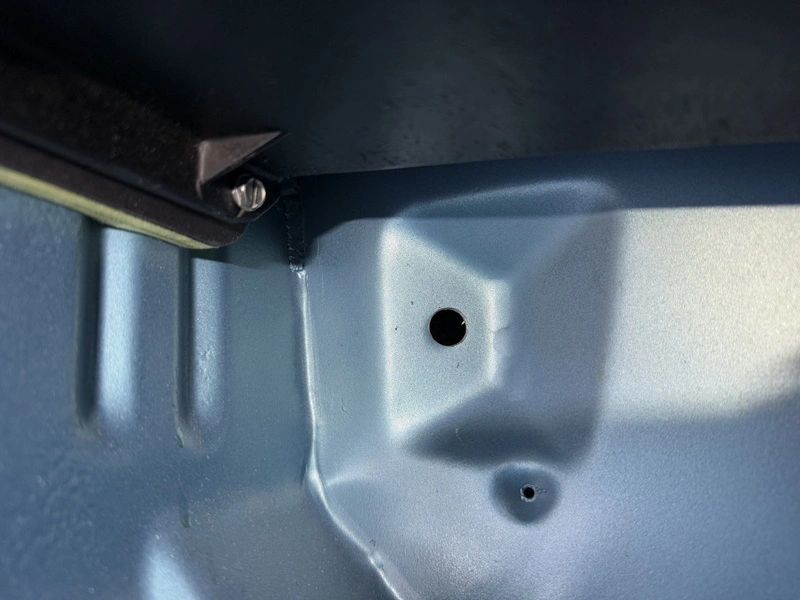 Metal surface with two drilled holes.