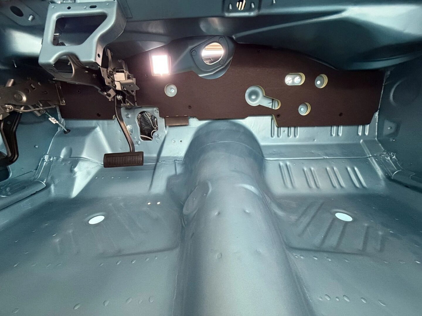 Car interior showing exposed metal floor.