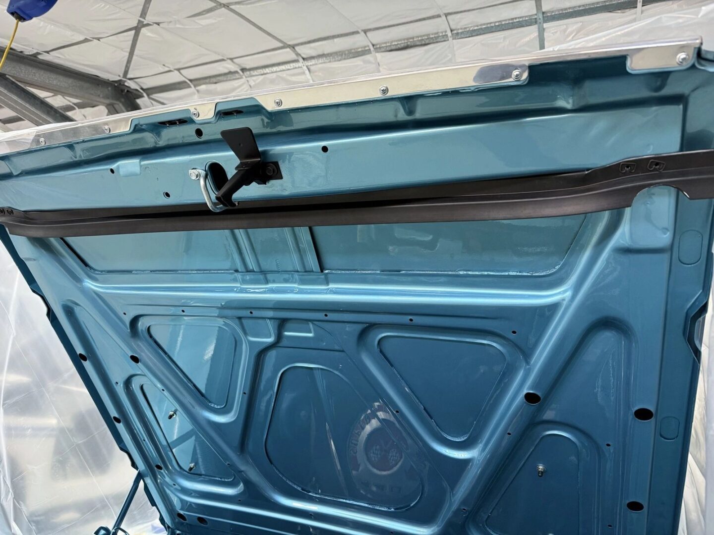 Blue car trunk interior with latch mechanism.