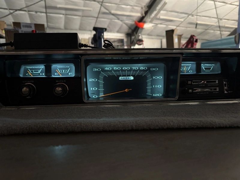Vintage car dashboard with illuminated speedometer.