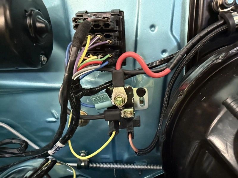 Car wiring and fuse box close-up.
