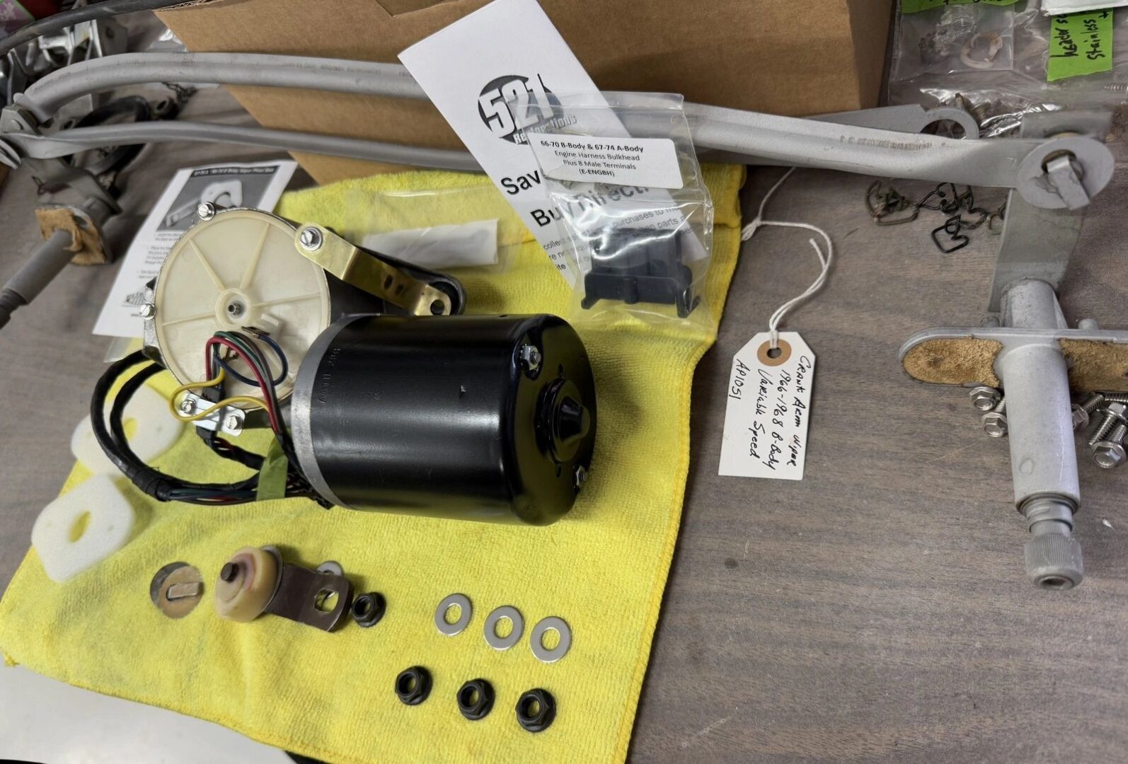 Car window motor parts on yellow cloth.