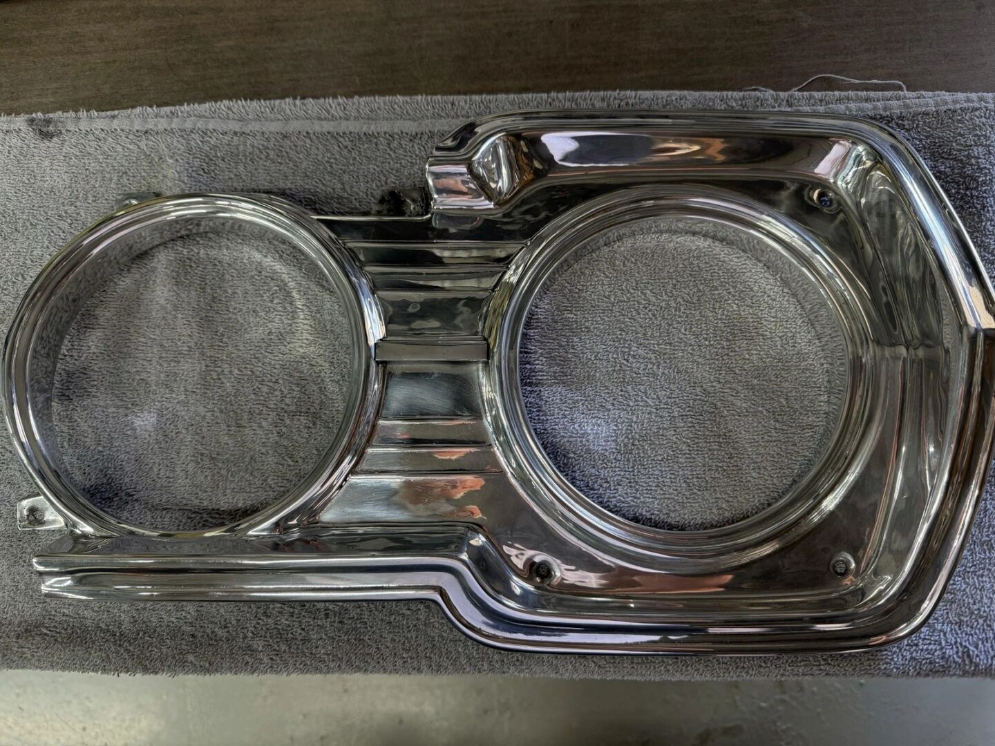 Car headlight bezel on gray towel.