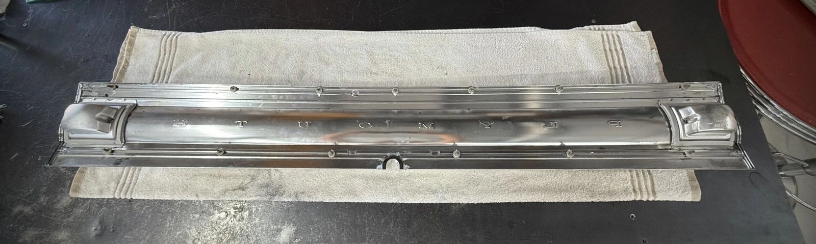 Metal component on white cloth surface.