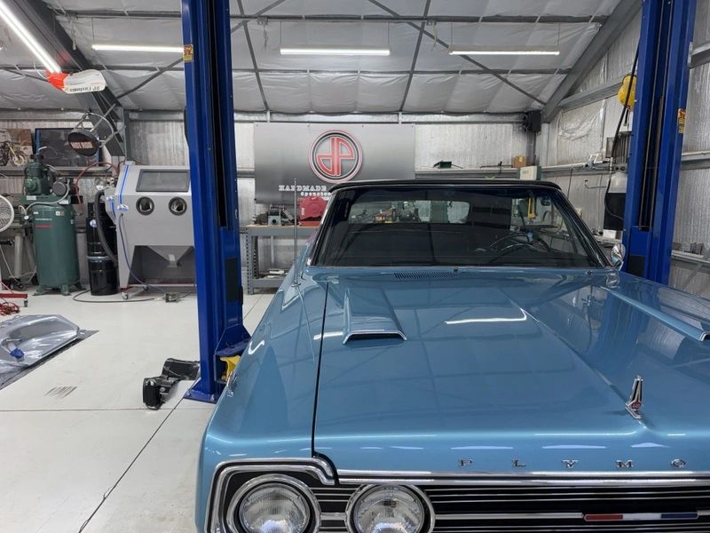 Blue vintage car in a garage workshop.