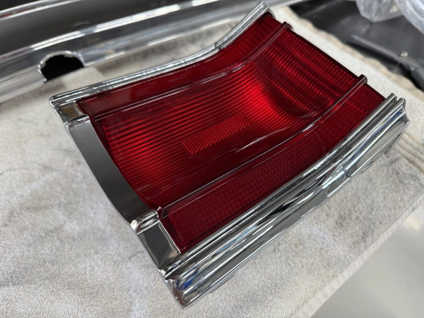 Red car taillight on a white surface.
