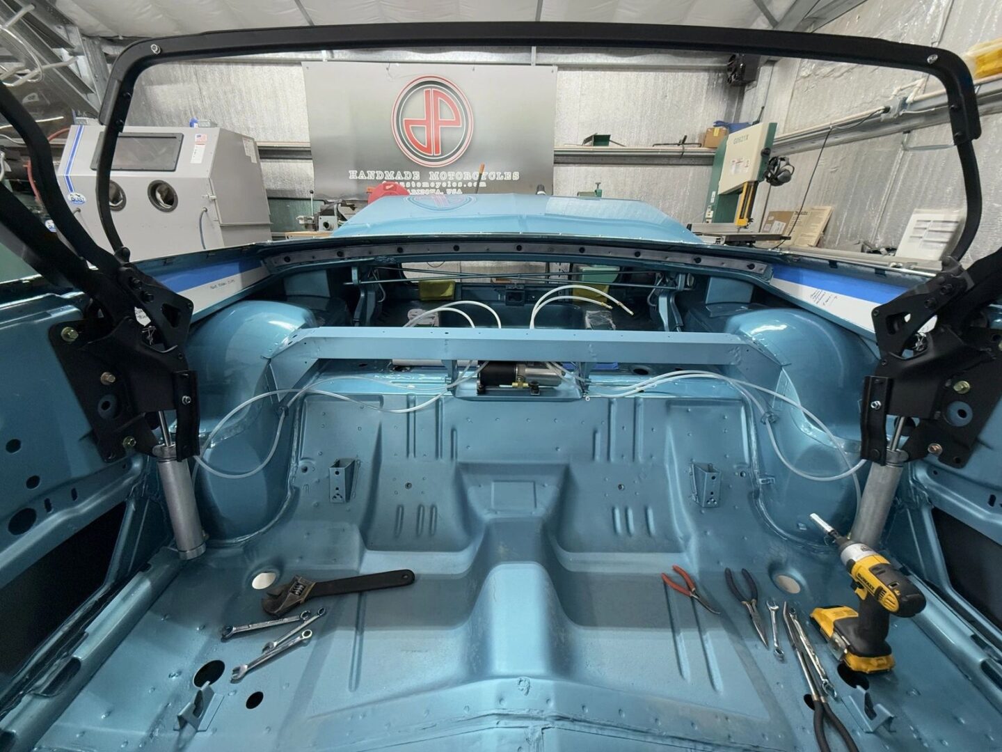 Car interior under restoration with tools.