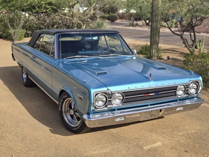Blue vintage convertible car on desert road.