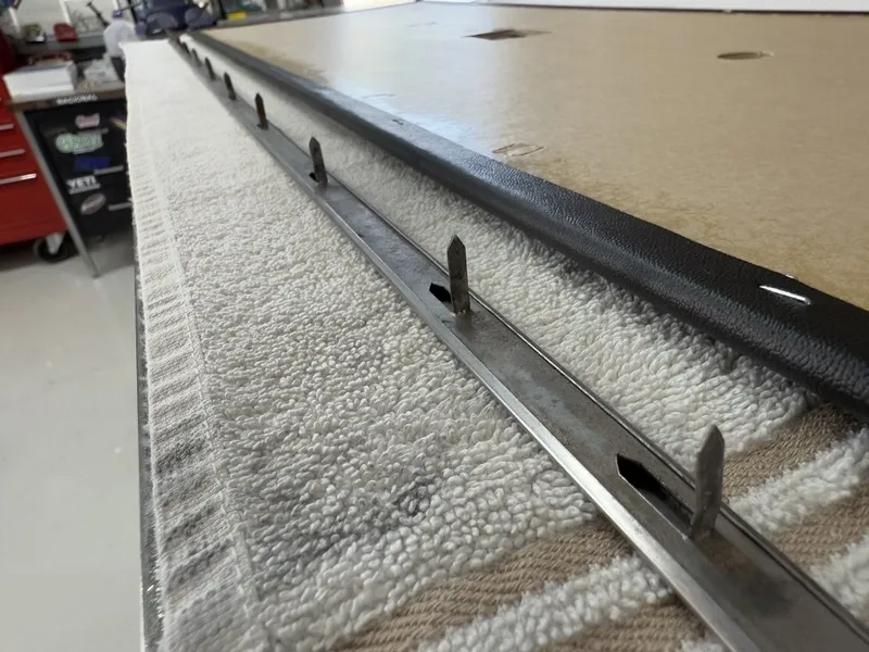 Metal strip with prongs on table edge.