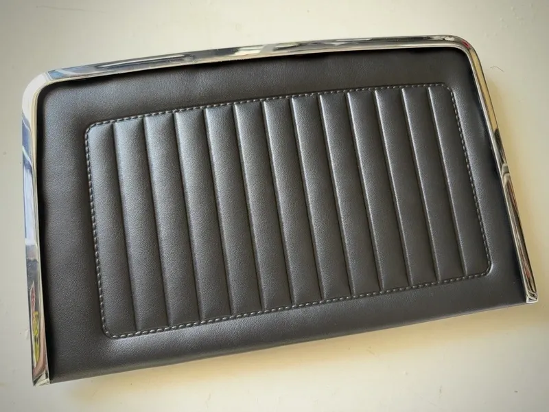 Black leather car door panel with trim.