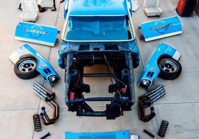 Disassembled car parts arranged on the floor.