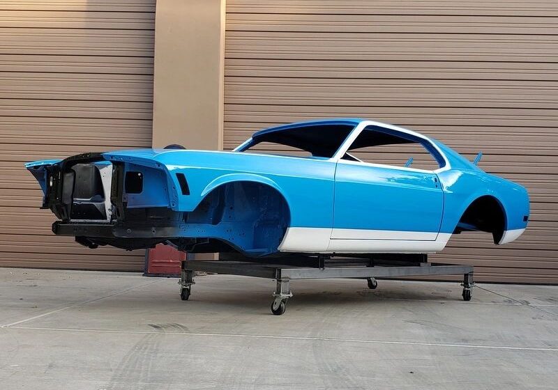 Blue classic car body on stand.