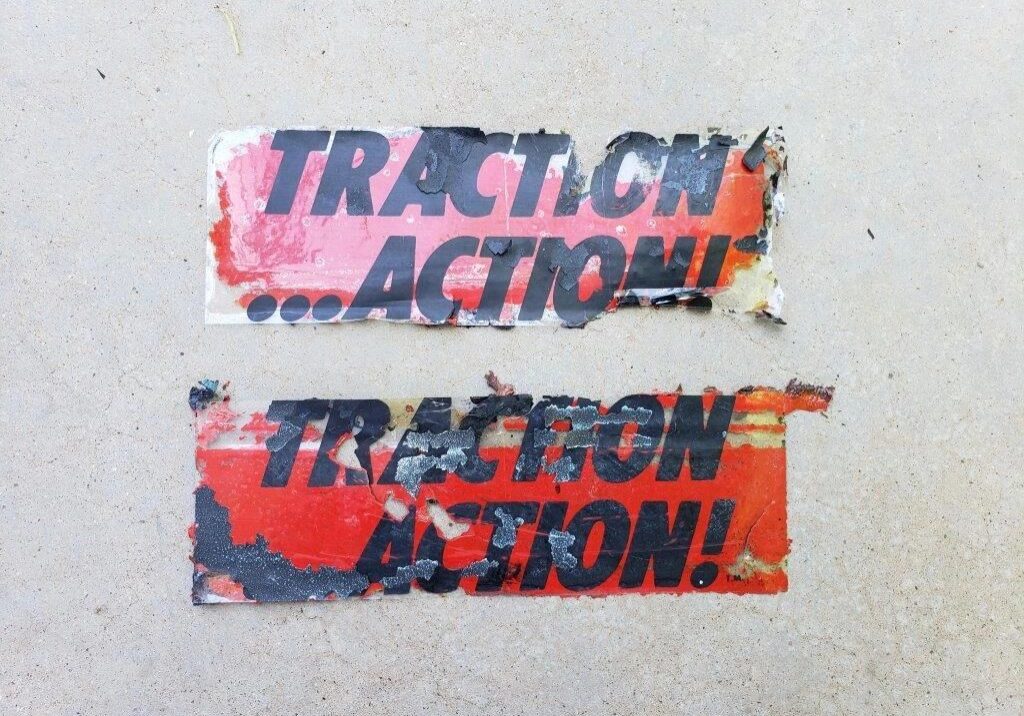 Two weathered "Traction Action" stickers.