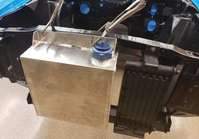 Car engine bay with metal tank installation.