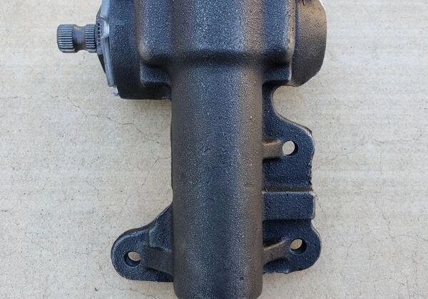 Metal steering gearbox on concrete surface.