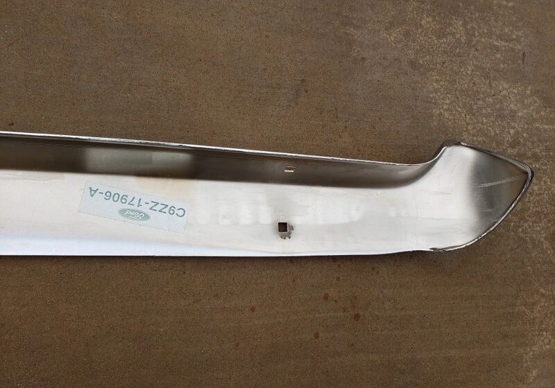 Metal car bumper on concrete surface.