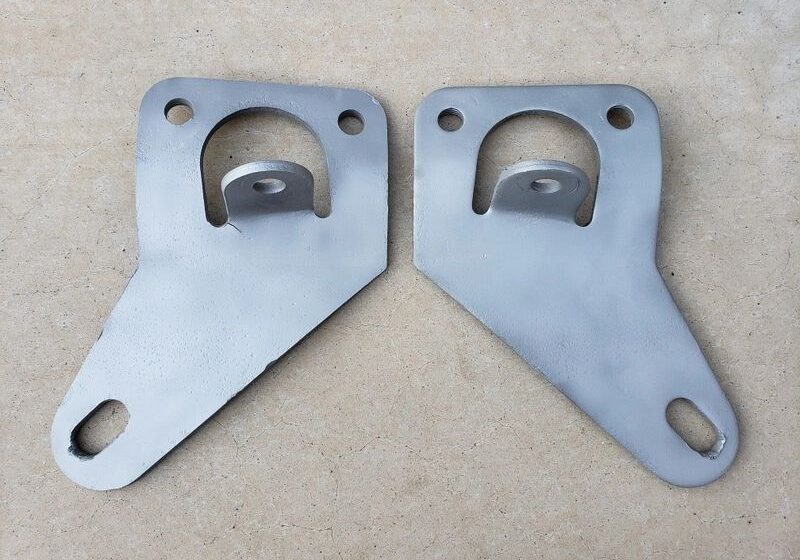 Two metal brackets on a flat surface.