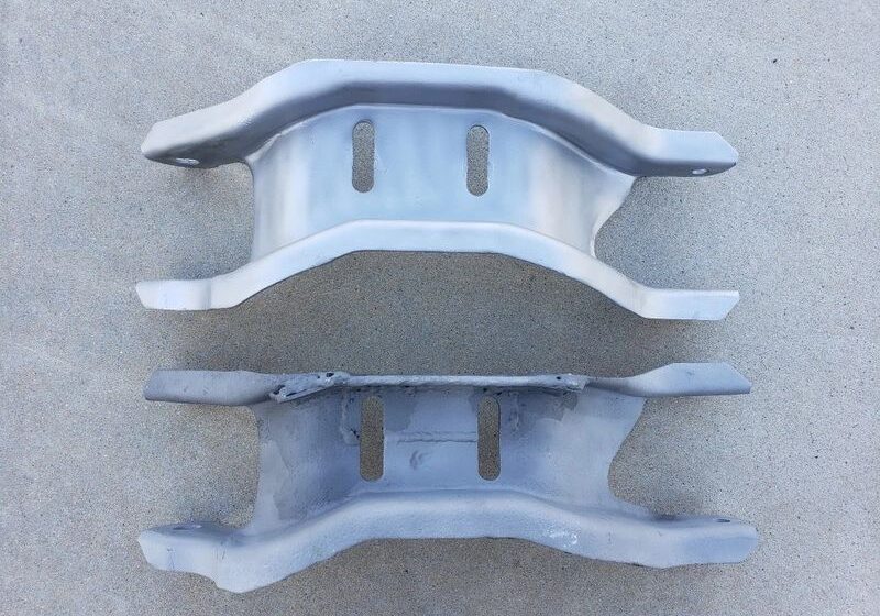 Two metal brackets on a concrete surface.