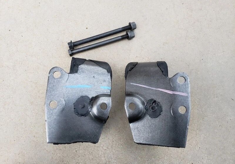 Metal brackets and bolts on concrete surface.