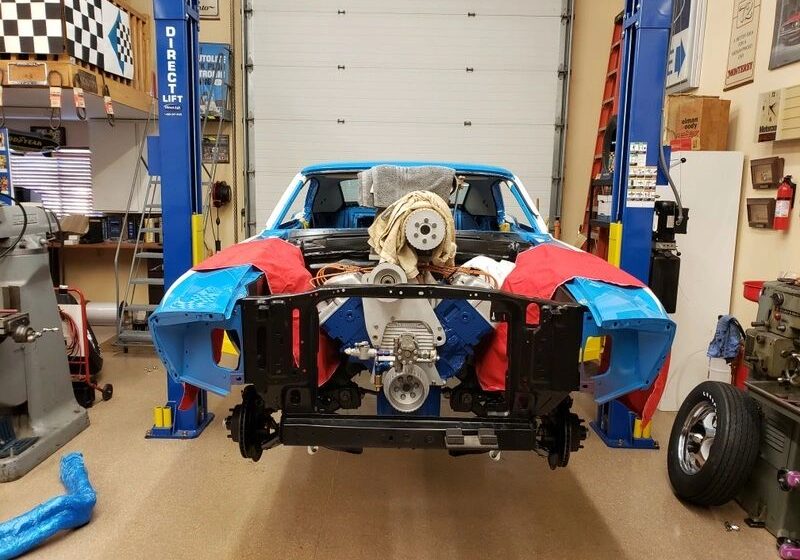Blue car under repair in garage.
