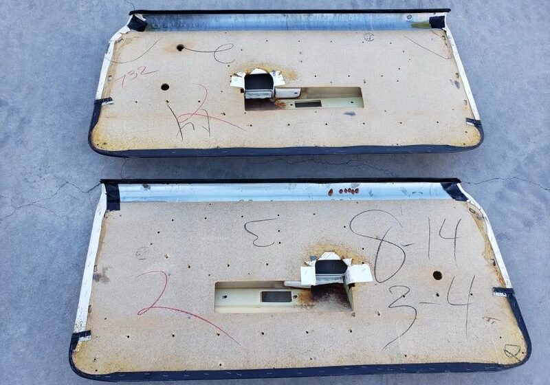 Two vintage car door panels with markings.