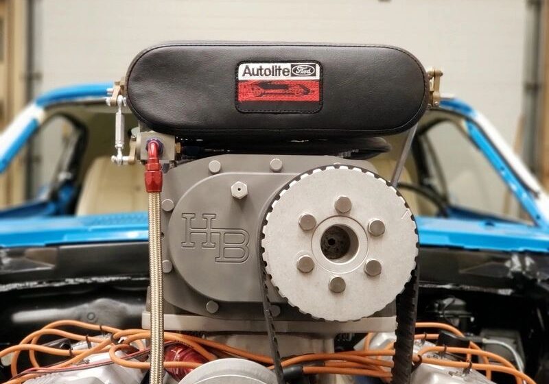 Car engine with Autolite logo, blue vehicle.