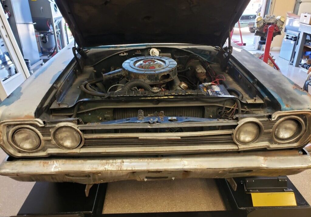 Classic car with hood open in garage.