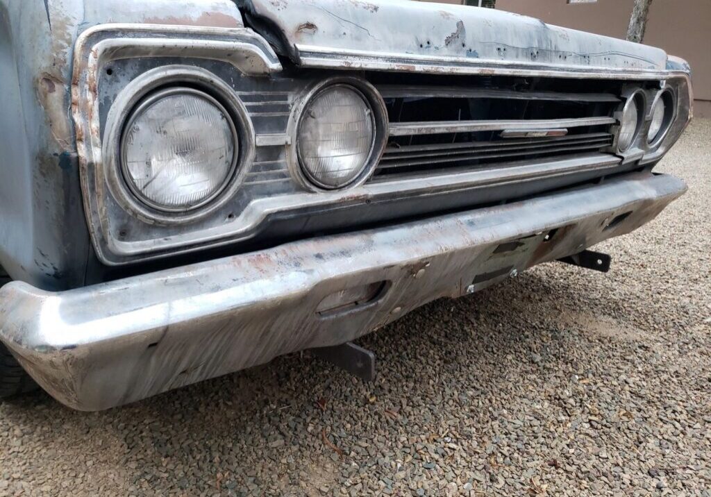 Vintage car front with dual headlights.