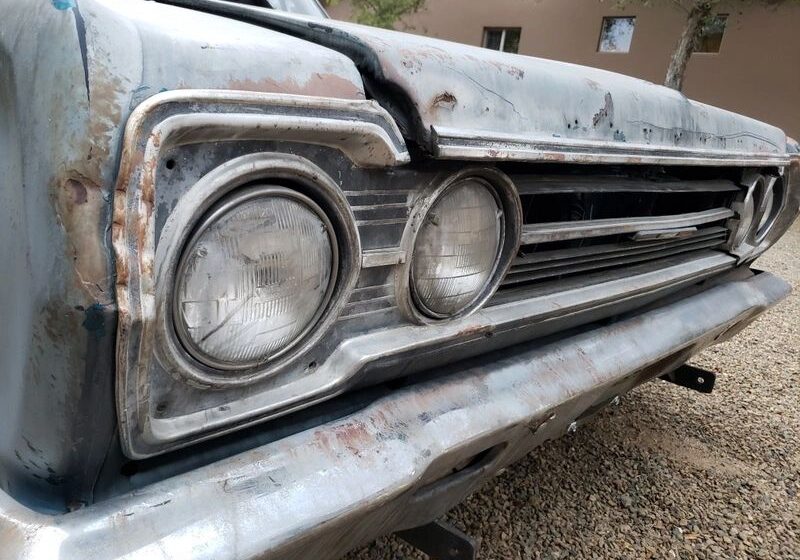 Close-up of a vintage car's rusty grille.