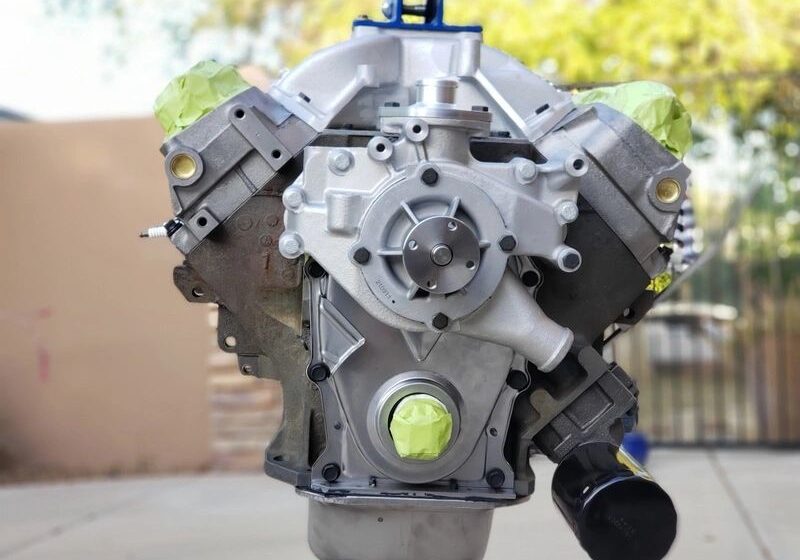 Car engine on display stand outdoors.