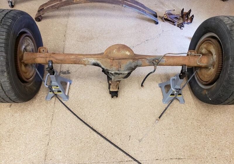 Car axle on jack stands in garage.