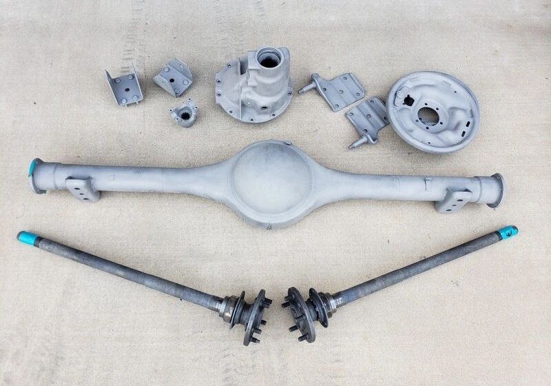 Car parts arranged on a concrete surface.