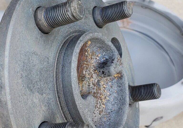 Rusty wheel hub with five bolts.