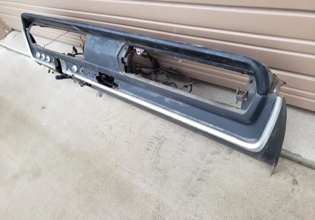 Car dashboard against a garage door background.